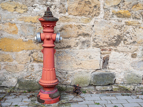 Fire hydrant red vintage metal against old stone wall