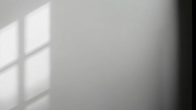 Soft window light casting geometric shadow on pale wall with minimalist calm mood and soft light