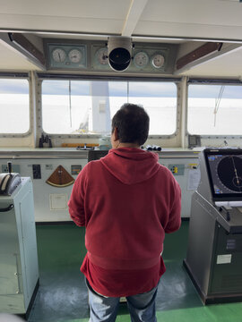 wheelman on the ship bridge steering course. navigation, nautical, marine equipment. seafarer job. 