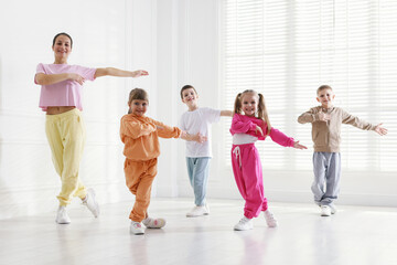 Naklejka premium Professional dance teacher training children in studio