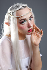 Naklejka premium Beautiful girl dressed as elf on grey background