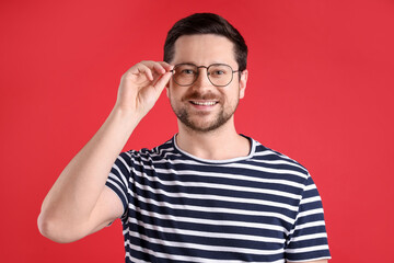 Fototapeta premium Portrait of smiling man on red background