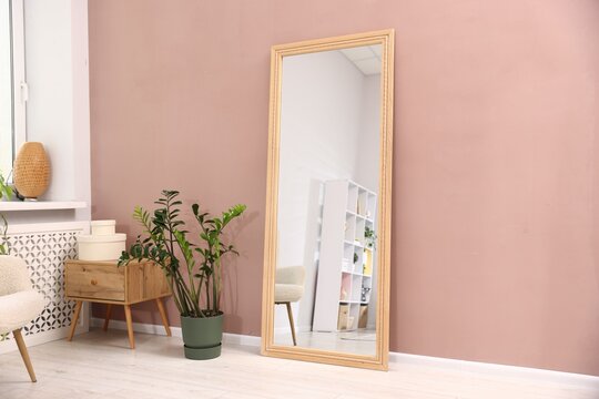 Stylish full length mirror near color wall indoors. Interior design