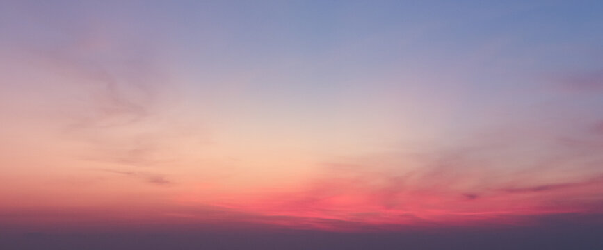 Vibrant sunset sky with soft pink and purple clouds over atmospheric horizon for nature background and abstract conceptual design