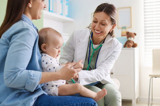Mother with her baby having appointment with pediatrician in hospital, closeup. Doctor checking child with stethoscope
