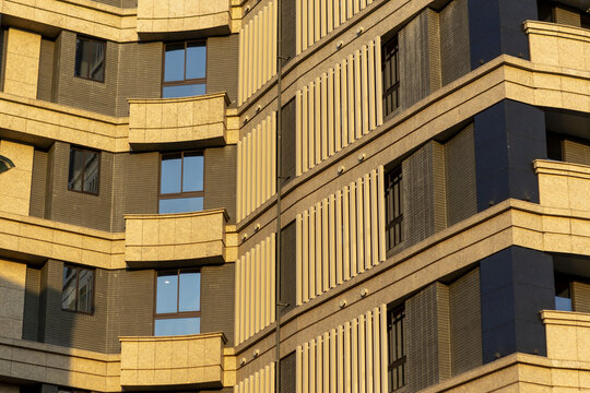 View of the modern facade of a residential building with balconies and architectural slats in warm sunlight Taipei City, Taiwan.