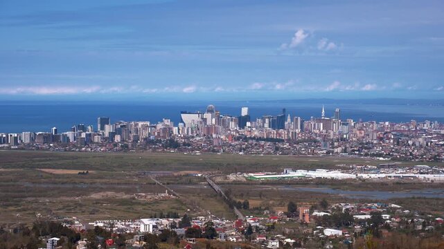 Expansive aerial panorama of batumi, georgia, featuring the modern city skyline and skyscrapers along the black sea coast with a view of the surrounding landscape, mountains and urban area