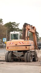 Pomarańczowa koparka kołowa marki Atlas 1304 na miejskim placu budowy podczas prac drogowych, prezentująca profesjonalny sprzęt budowlany wykorzystywany do modernizacji infrastruktury miejskiej © tomo81