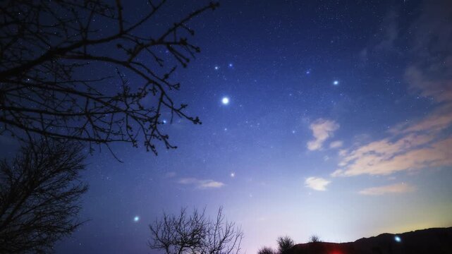 Orion constellation and Milky Way star-trails on a dark countryside skies. Time-lapse video.