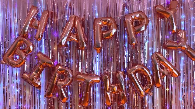 Happy Birthday balloon letters on shiny tinsel curtain background, festive party decoration celebration. Shiny tinsel curtain background with colorful glitter and sparkling lights, festive party decor