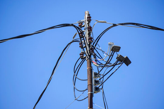 Old worn electrical power wires on urban building