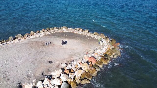 Aerial View of Man Fishing by the Sea in Izmir Turkiye Drone Shot
