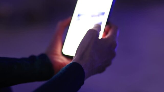 Woman using smartphone by pool at night &ndash; glowing screen, copy space, modern lifestyle.