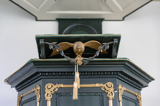 View of the historic pulpit with a golden eagle lectern and ornate gold decorations inside the Enskerk in Schokland, Flevoland, Netherlands.