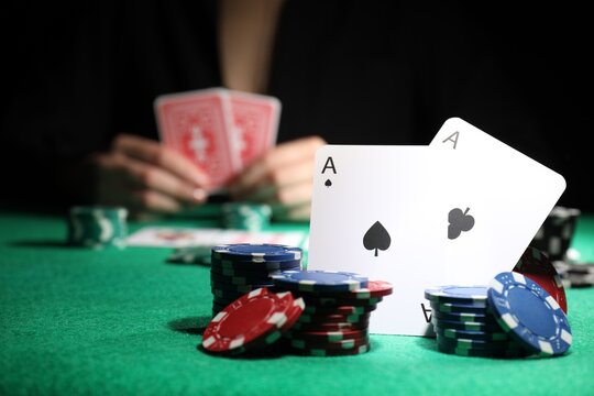 Woman at green table, focus on playing card and casino chips