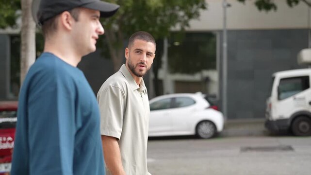 Two men walk side by side on a paved street. They wear casual attire, one with a cap. Their expressions are neutral, focused on forward motion. Delivery truck rests parked nearby
