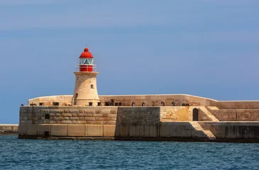 Fototapeten Mediterranes Europa Stone lighthouse with red lantern on the breakwater in Grand Harbour of Valletta, Malta. Historic maritime structure on the Mediterranean coast  © Kavalenkava