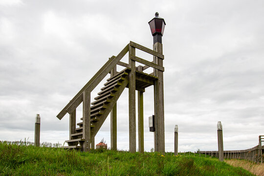 View of the historic wooden harbor light on a grassy hill under an overcast sky in Schokland, Flevoland, Netherlands.