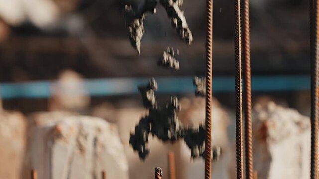 Pouring concrete mix into rebar structure during foundation work close up