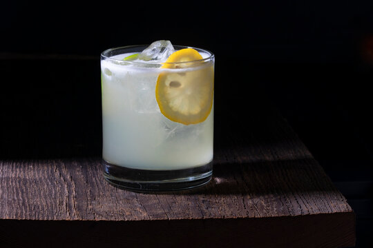 Cocktail with lemon slice on black