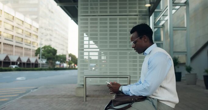 Serious, businessman and texting with phone at bus stop, travel or communication with contact on web. Outdoor, employee and black person with mobile for chat, commuting and waiting for transport