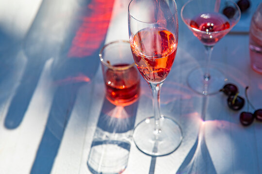 Pink drinks with cherries, backlit with shadows