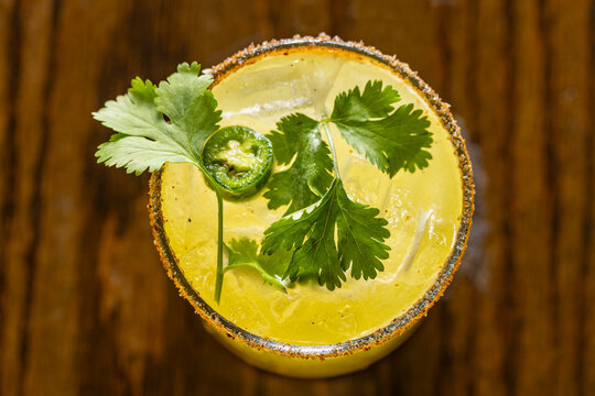 Overhead shot of margarita with cilantro, jalapeno and salt edge