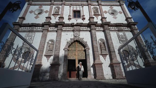 Mature woman explores Mission Church in San Ignacio, Baja California, Mexico while enjoying the sights and culture of the area.
