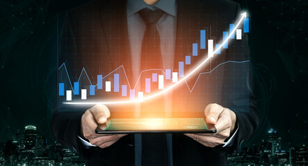 A businessman stands confidently holding a tablet displaying a rising graph, symbolizing financial growth and success in a digital market. Impute © InfiniteFlow