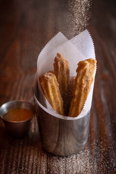 Churros with sugar being sprinkled on them