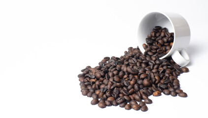 Obraz premium Roasted coffee beans spilling from a white isolated cup, cafe concept with copy space