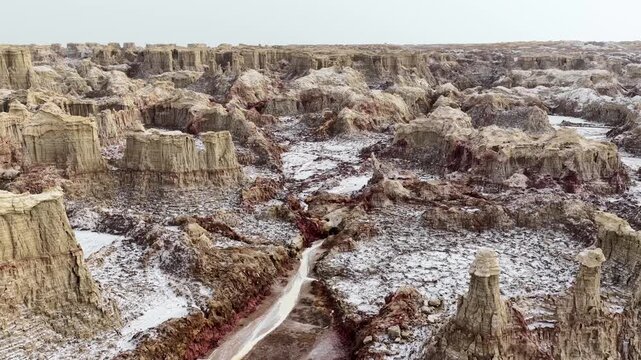 Aerial view of the unique salt formations and rugged volcanic landscape of the Danakil Desert with mineral deposits in Dalol, Afar, Ethiopia.