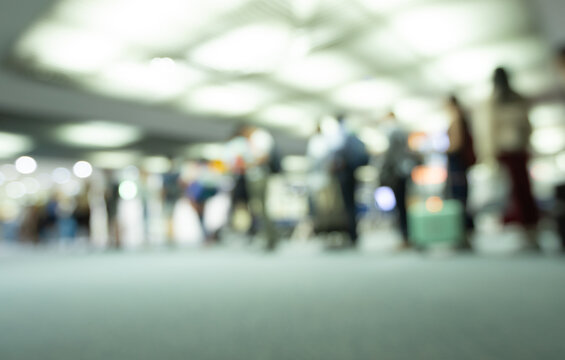 Blurred abstract background of passengers queueing at airport terminal gate for boarding an airplane