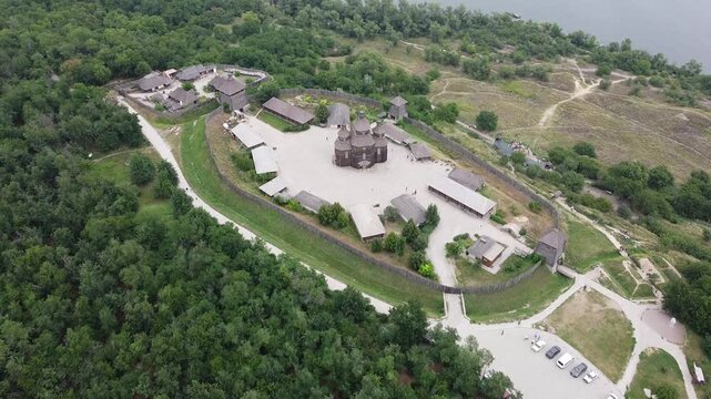 Horizontal drone view of Khortytsia Island with an ancient Cossack settlement, river, and forest landscape in Ukraine