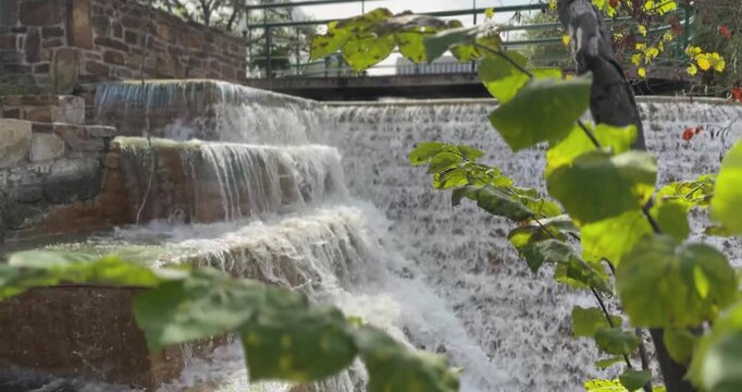 Closeup of a cascading waterfall, concrete water feature in a commercial, intuitional garden.
