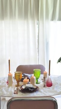Elegant vertical composition of a person preparing a celebration table with stylish tableware and decor.