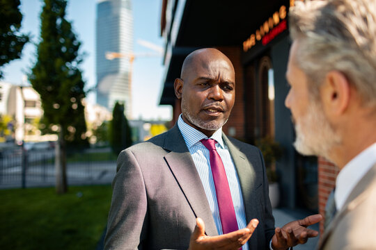 Businessmen discussing strategy outside urban office