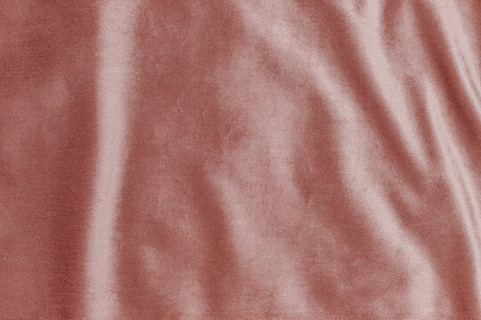 Fabric texture shows soft pink velvet with gentle folds and creases in natural light during daytime