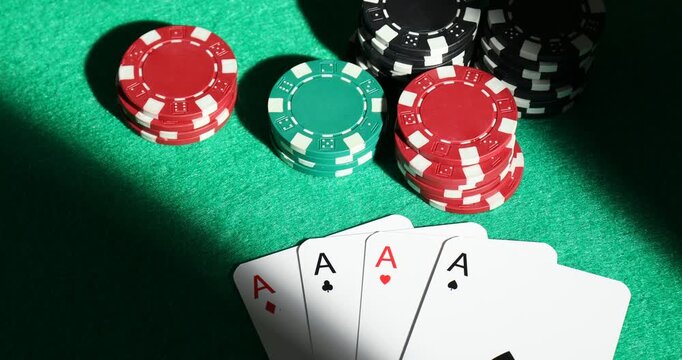 Casino chips and playing cards on green table