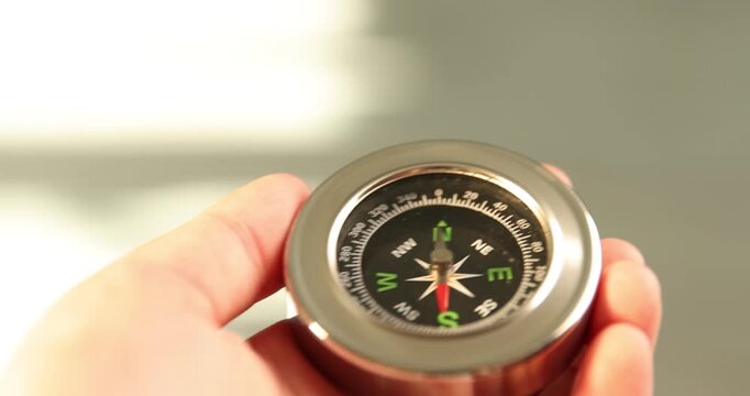 Man with compass on light background, closeup