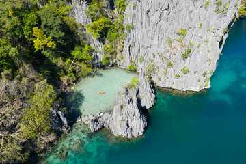 Kayakers explore Big Lagoon, found amid the scenic limestone islands of El Nido. This area in the Philippines is a popular vacation destination due to its beautiful coral reefs, beaches, and lagoons. © ead72