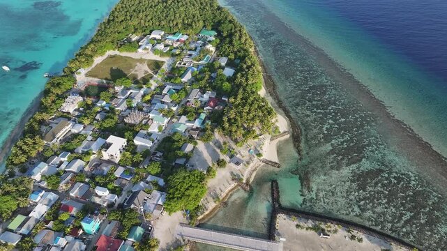 Aerial view of the tropical village on Fulhadhoo island with palm trees, turquoise lagoon and coral reefs Fulhadhoo, Baa Atoll, Maldives.