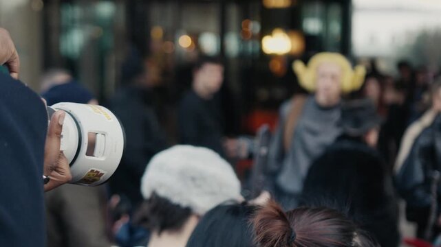 Videographer filming a crowd at an outdoor public event