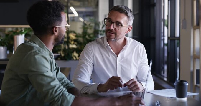 Business men, management collaboration and laptop with web design and communication at desk. Teamwork, boss and digital graphic discussion in a office with professional employee and work planning