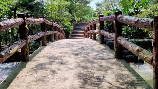 a video of a bridge in the park over the river