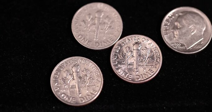 Several old worn dime coins on a black background, a group of old worn and scratched 10 cent coins in close-up on black velvet, close up