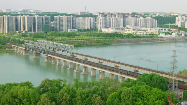 Freight train and passenger train pass each other quickly in opposite directions on the railway bridge.