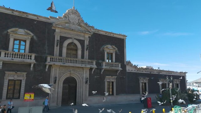The historic Old City Hall building in Ciudad Juarez, Mexico. The stone facade features traditional neoclassical architecture with arched doorways and balconies.