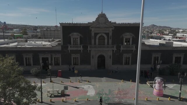 The historic Old City Hall building in Ciudad Juarez, Mexico. The stone facade features traditional neoclassical architecture with arched doorways and balconies.