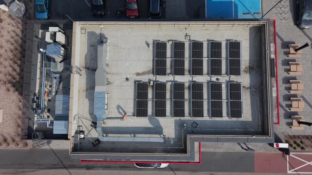 Aerial Rooftop Solar Panel Array Over Commercial Flat Roof, Energy Auditor Vibe, Grid Connected Modules, HVAC Units, Parking Lot, Curbside Pickup Lane, Midday Sun, Closeup Drone Sweep